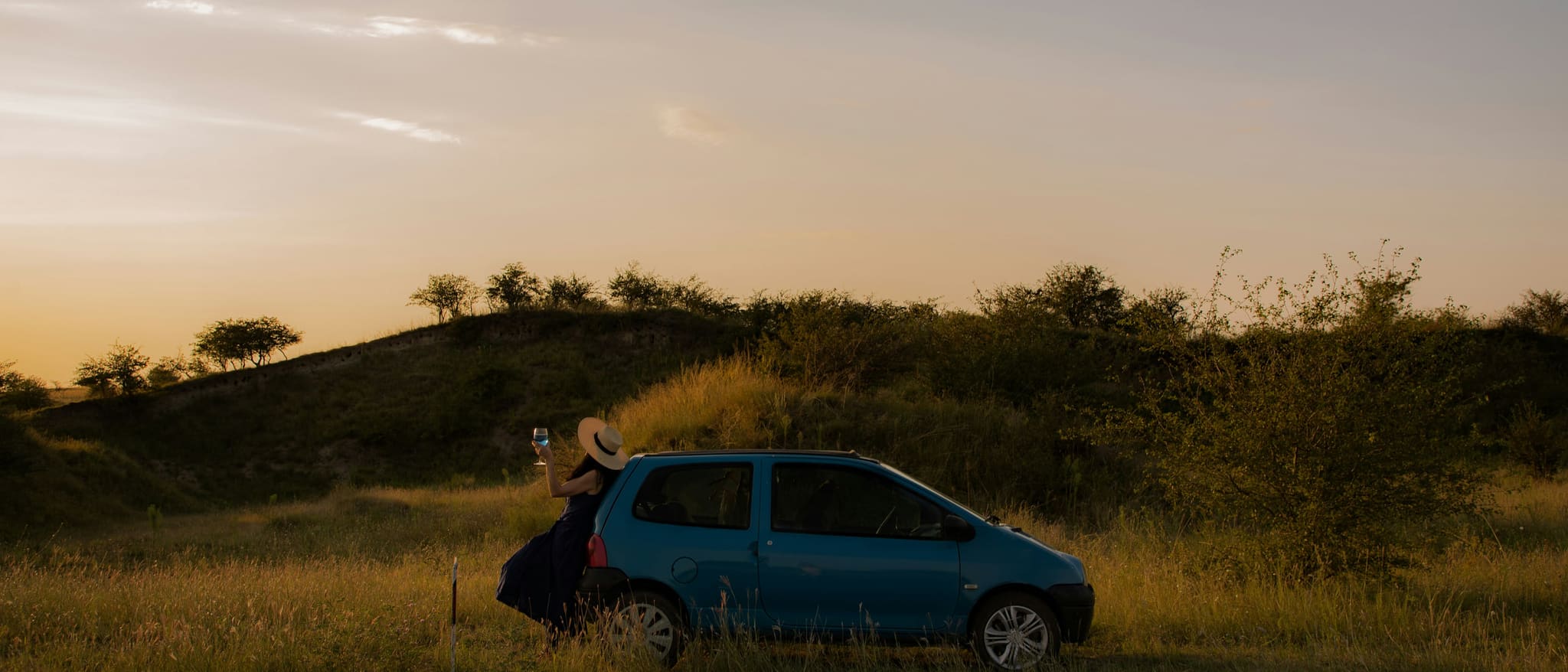 Symbolbild: Ein kleines Auto steht bei Abendlicht am Rand einer Landstraße.